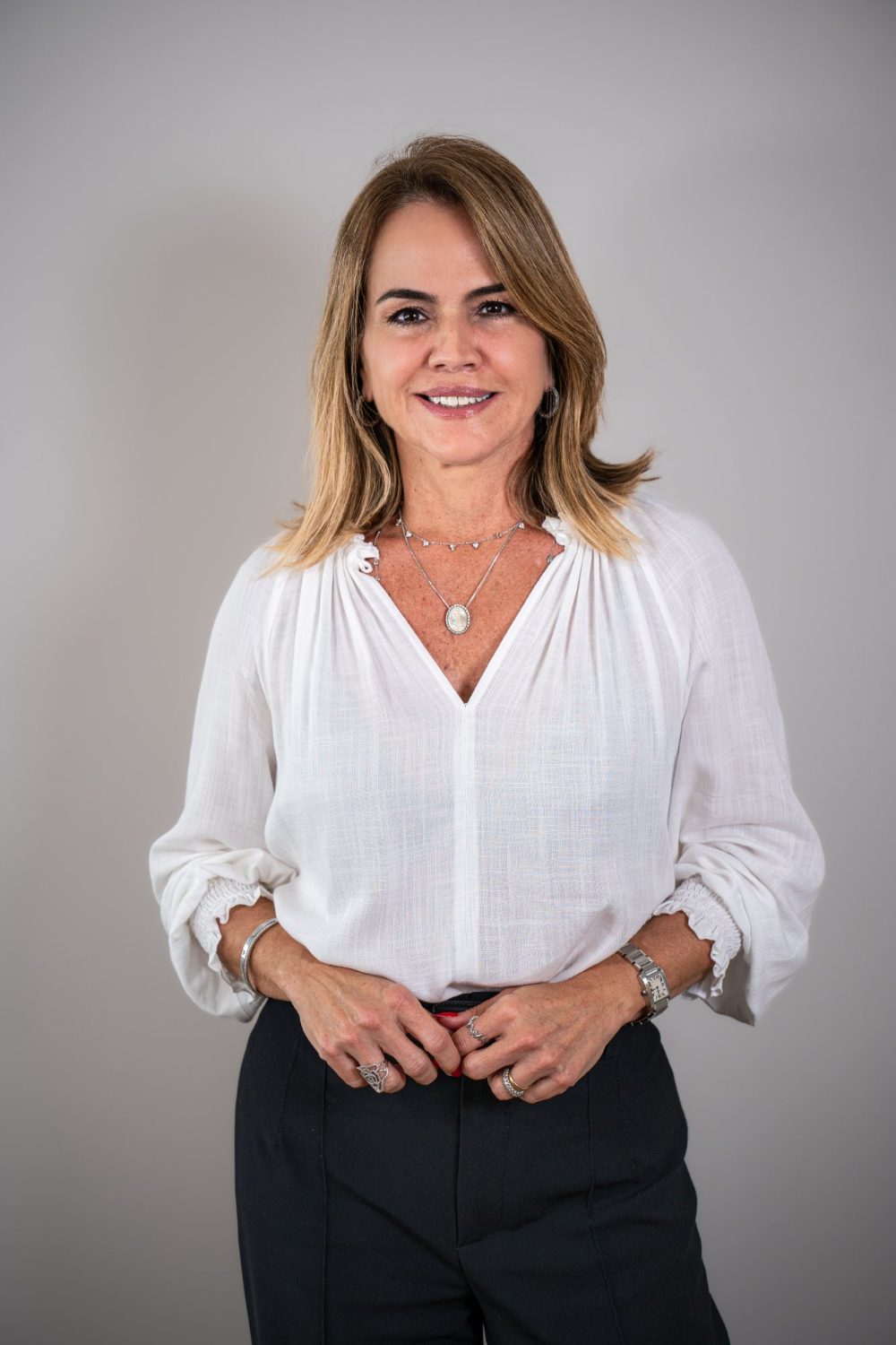 Retrato de Lecticia Raposo sorrindo, com blusa branca